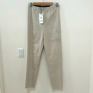 Brand new leggings, leather like material, stained in the left side